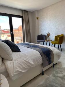 a bedroom with a large bed and a large window at Bella Address Hotel Beach in Saïdia