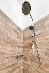 a shower with a shower head in a bathroom at Between the roofs of Menton old town and the sea in Menton +18 photos