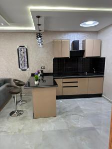 a large kitchen with a counter and a table at Bella Address Hotel Beach in Saïdia