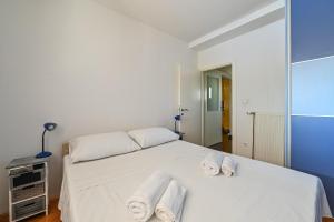 Un dormitorio con una cama blanca con toallas. en Apartment Dada Zadar -Excellent apartment nearby old city en Zadar
