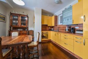 cocina con armarios amarillos y mesa de madera en Apartment Dada Zadar -Excellent apartment nearby old city en Zadar