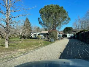 una entrada que conduce a una casa con un árbol en Villa entre bordeaux et saint emilion, en Cursan