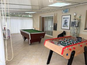 a room with a foosball table and a pool table at Villa entre bordeaux et saint emilion in Cursan