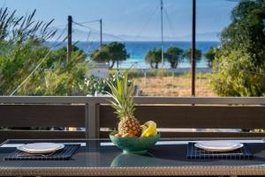 a bowl of pineapple on a table with a view of the beach at Odyssea Sea View Apartment one minute from the sea in Kremasti