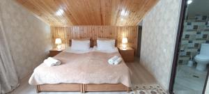 a bedroom with a bed with two towels on it at Guest House Tamta in Stepantsminda