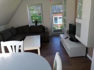 a living room with a couch and a tv at Ferienwohnung Muschelsucher in Schlagsdorf auf Fehmarn in Fehmarn