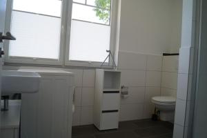 a bathroom with a sink and a toilet and a window at Ferienwohnung Muschelsucher in Schlagsdorf auf Fehmarn in Fehmarn +15 photos