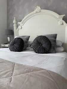 uma cama branca com duas almofadas em cima em Baytree House em Lowestoft