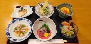 a tray with four bowls of different types of food at Tsubamesanjo Washington Hotel in Sanjo
