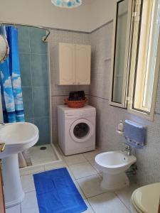a bathroom with a washing machine and a sink at Casa vacanze Il sorriso di Emi in Torre Suda