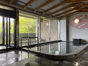 a swimming pool in a house with a glass floor at Kokumin Shukusha Marine Terrace Ashiya in Kitakyushu
