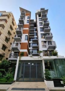 wysoki budynek apartamentowy z dużymi szklanymi drzwiami w obiekcie Dianella Inn w mieście Dhaka