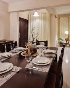a dining room table with plates and wine glasses at Dianella Inn in Dhaka