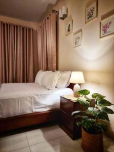 a bedroom with a bed and a table with a plant at Dianella Inn in Dhaka