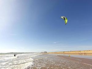 a person is flying a kite on the beach at Maison Saint-Hilaire-de-Riez, 3 pièces, 4 personnes - FR-1-224C-150 in Saint-Hilaire-de-Riez