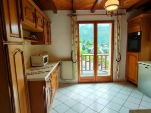a kitchen with a stove and a door with a balcony at Maison Cauterets, 9 pièces, 15 personnes - FR-1-234-244 in Cauterets