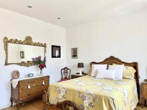 ein Schlafzimmer mit einem Bett, einem Spiegel und einer Kommode in der Unterkunft Moderno y amplio apartamento en el centro de Roses in Roses
