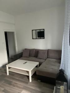 een woonkamer met een bank en een salontafel bij Logement T2 terrasse vue sur piscine in Larche