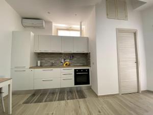 Una cocina con gabinetes blancos y un horno de estufa. en Casa Carlotta - Holiday House, en Conversano 20 fotos más