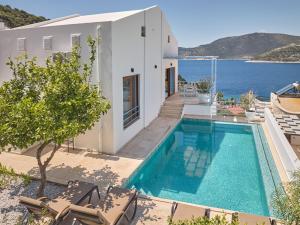 a house with a swimming pool next to the ocean at Villa Elmas in Kalkan
