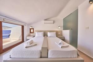 two beds in a room with a window at Villa Elmas in Kalkan