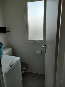 a small bathroom with a toilet and a window at Mobil home Menanteau in Les Mathes