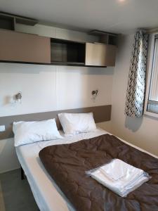 a bedroom with a large bed in a room at Mobil home Menanteau in Les Mathes