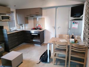 a small kitchen with a table and a dining room at Mobil home Menanteau in Les Mathes