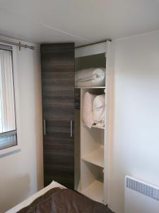 a bedroom with a closet with wooden doors at Mobil home Menanteau in Les Mathes