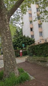 un árbol frente a un edificio alto en Appartement 3 pièces avec parking couvert gratuit., en Le Pré-Saint-Gervais