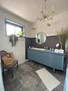 a bathroom with a sink and a mirror and a chair at Maison sur cour in Courzieu
