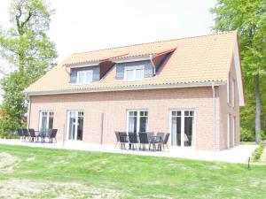uma casa de tijolos vermelhos com cadeiras pretas em frente em Ferienhaus Sonnenzauber 2 em Walsrode