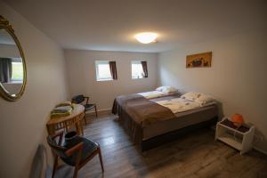 una camera da letto con un letto, un tavolo e uno specchio di Húnaver Guesthouse a Blönduós