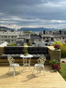 a couch and two chairs and a table on a deck at Basement apartment with parking in Ålesund