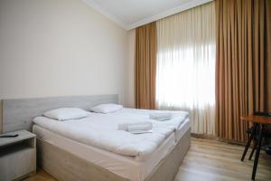 a bedroom with a bed with white sheets and a window at city point in Kutaisi