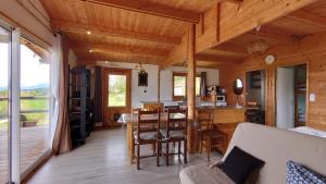 a living room with a table and a dining room at Les Chatcureuils in Montclar