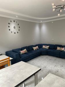 a living room with a blue couch and a clock on the wall at Sunrise Ureki in Ureki