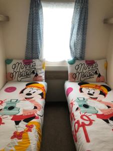 two beds with mickey mouse pillows in a room at Lunas chill pad in Edinburgh