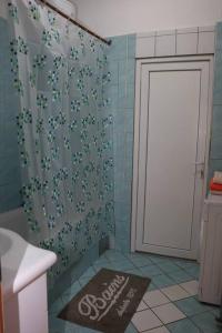 a bathroom with a shower curtain and a welcome mat at Apartman Lagodi in Križevci