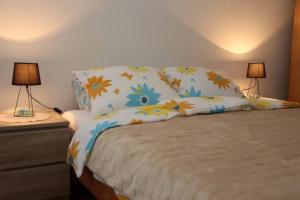a bed with two lamps and two pillows on it at Apartman Lagodi in Križevci