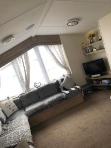 sala de estar con sofá y ventana grande en Lunas chill pad, en Edimburgo