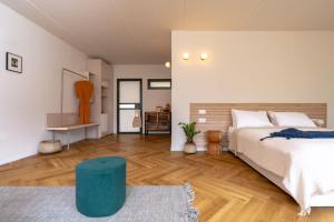 Moran的住宿－Slowness - Kibbutz Moran，一间卧室设有一张大床和一张蓝色凳子