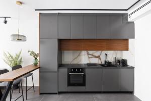 a kitchen with gray cabinets and a wooden table at Old North New&Amazing by TLV2RENT in Tel Aviv