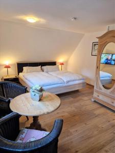 Schlafzimmer mit einem Bett, einem Tisch und einem Spiegel in der Unterkunft Ferienhaus Zum Amthof in Alsfeld