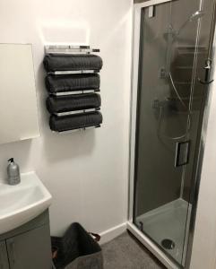 a bathroom with a shower and a sink and towels at Large Three Bedroom Apartment with Roof Terrace Near City Centre in Cardiff