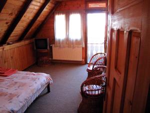 a bedroom with a bed and chairs and a television at Casa Oana in Sulina