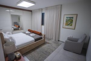 ein Schlafzimmer mit einem Bett, einem Stuhl und einem Spiegel in der Unterkunft Luxury apartments Boutique Haneviim in Jerusalem