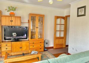 een woonkamer met een tv op een houten entertainmentcentrum bij Apartamento Bellavista in Portonovo