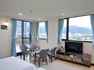 1 dormitorio con 1 cama, sillas y TV en 藍洋呂遊 宜蘭頭城, en Toucheng