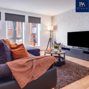 a living room with a couch and a tv at Pluxa Sunstone Deluxe - Spacious Birmingham City Centre Stay in Birmingham